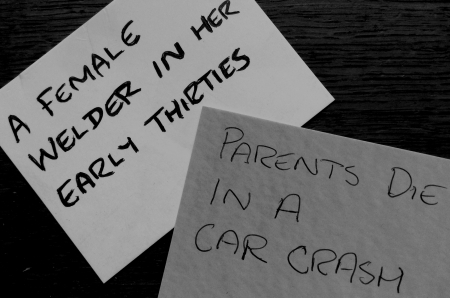 Plot Cards, First: A female welder in her early thirties. Second: Parents die in a car crash